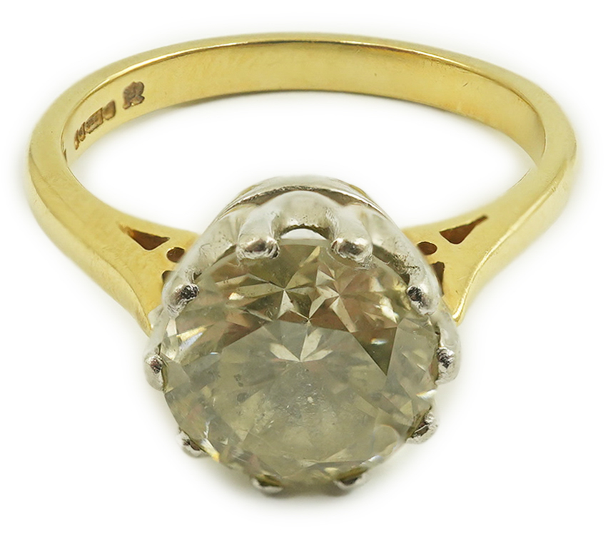 A modern 18ct gold and solitaire round cut diamond set ring